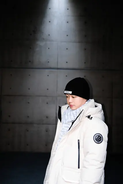 Jason beneath a shaft of light against a concrete wall